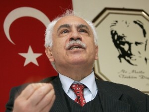 Turkish Workers Party (IP) leader Dogu Perincek gestures in front of his national flag and a portrait of Mustafa Kemal Ataturk during a press conference on the eve of his trial on denial of genocide 05 March 2007 in Renens. Perincek gave a speech on the Armenian genocide during a celebration of the 82nd anniversary of the 1923 Treaty of Lausanne which fixed the borders of modern-day Turkey.  AFP PHOTO / FABRICE COFFRINI
